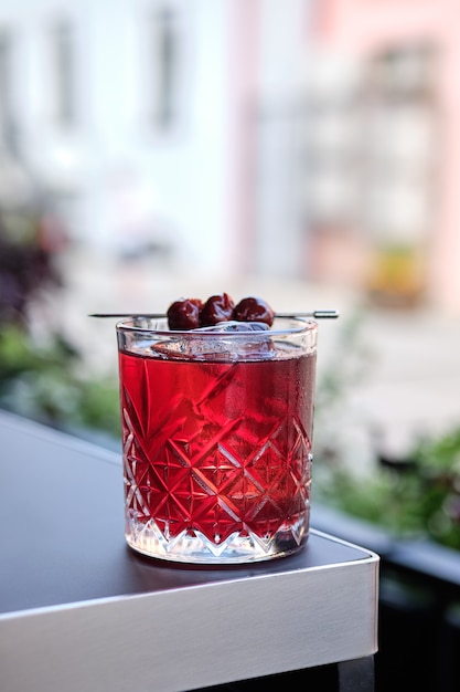 Cóctel de cerezas en el borde de la mesa en la terraza al aire libre (foto con poca profundidad de campo)