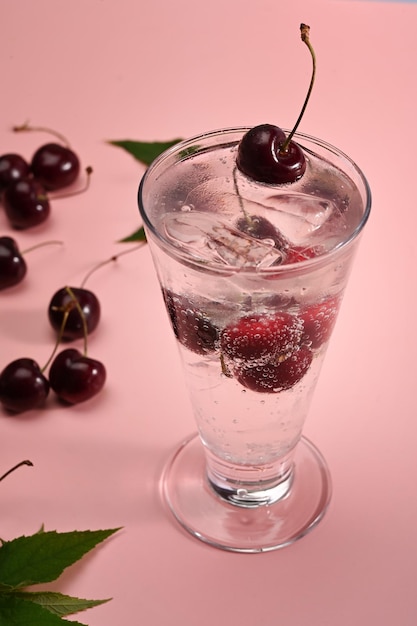 Cóctel de cerezas frescas sobre fondo rosa