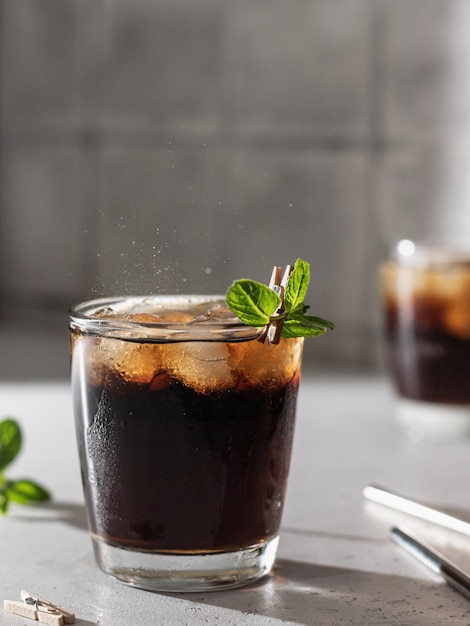 Cóctel de cola o cuba libre en vaso con cubitos de hielo y menta y pajitas de metal Refresco de cerca Espacio de texto