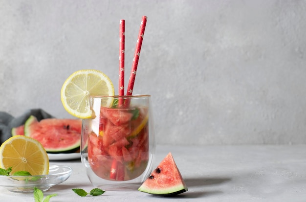 Cóctel Cold Bright Watermelon Mojito con rodajas de limón menta y pajita para beber