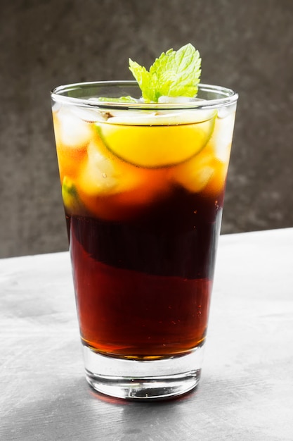 Cóctel Cuba Libre en un vaso sobre un fondo oscuro