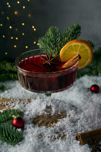 Cóctel festivo estilizado en la nieve y ramas de abeto dispersas