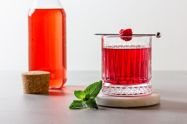 Foto cóctel de frambuesa en un vaso en un soporte de mármol