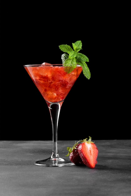 Cóctel de fresa de verano frío mojito margarita daiquiri en una copa de martini sobre fondo oscuro de cerca