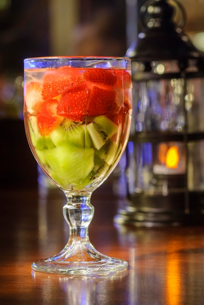 Cóctel con fresas y kiwi en el mostrador del bar con fondo borroso