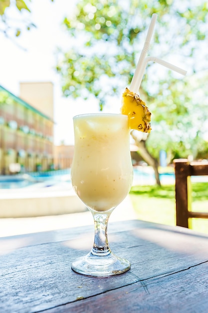 Cóctel frío de piña colada en un vaso sobre la mesa en el café al aire libre