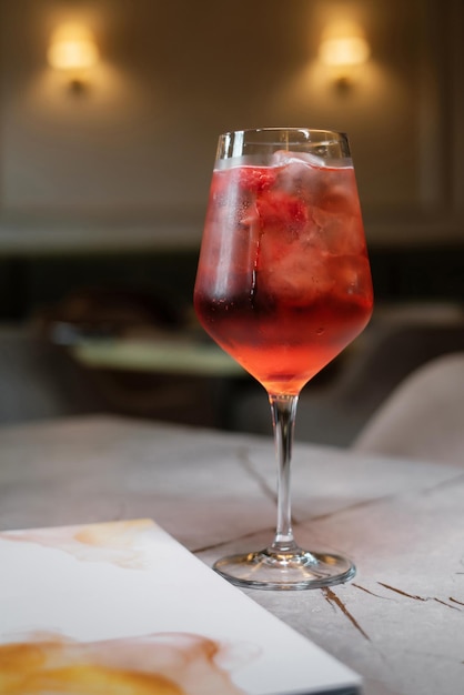 Cóctel de frutas con carta de bebidas en mesa de piedra