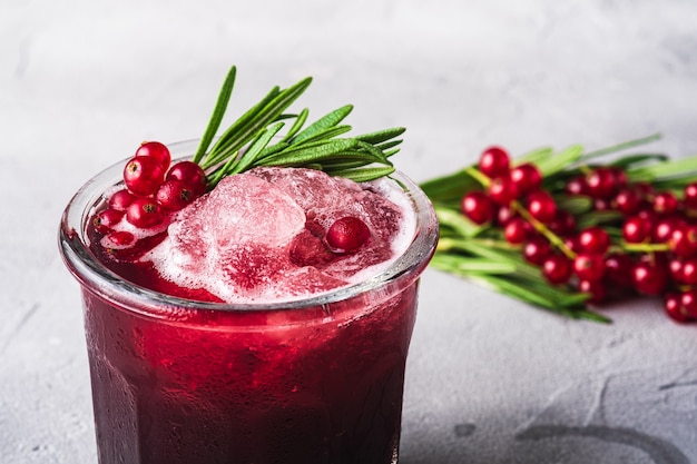 Cóctel de frutas frescas en vidrio, refrescante bebida de bayas de grosella roja de verano con hojas de romero