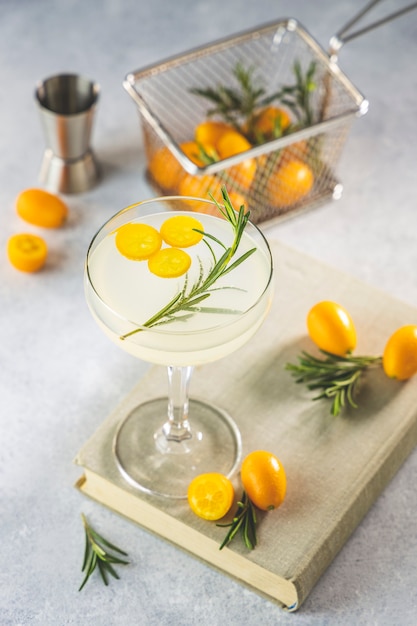 Cóctel de gin tonic con kumquat fortunella en copa de champagne