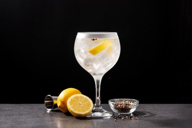 Cóctel de gin tonic en un vaso sobre fondo negro