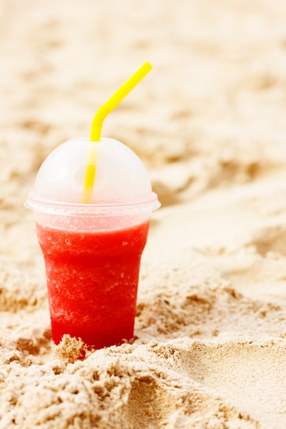 Cóctel helado de frutas rojas en la arena de la playa