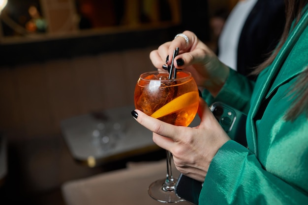 Cóctel italiano Aperol Spritz con rodajas de naranja sobre una mesa de piedra gris. Bebida de verano, sangría casera.