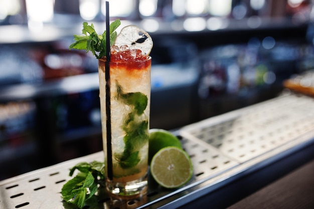 Cóctel largo alcohólico con menta y limón en vaso en la mesa de bar