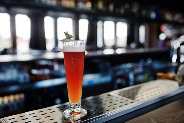 Cóctel largo alcohólico en vaso en la mesa del bar