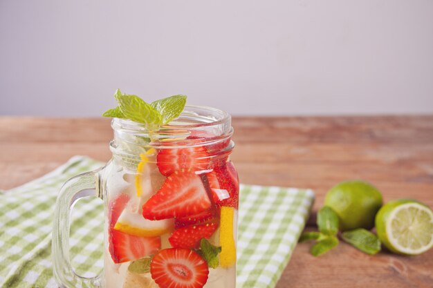 Cóctel de limonada o mojito con limón, fresas y menta.