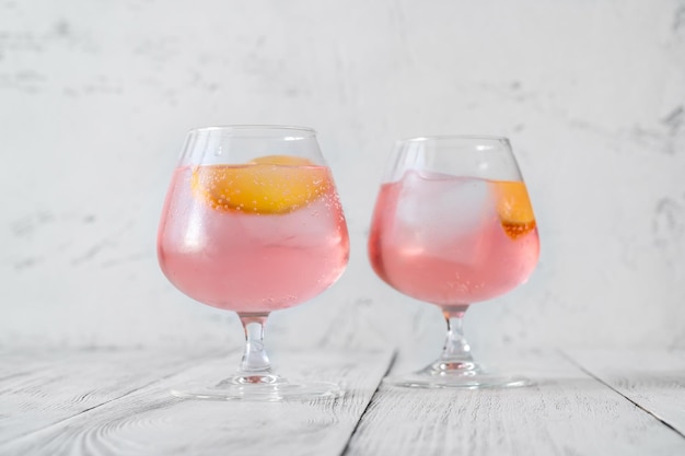 Cóctel de limonada de vodka rosa adornado con una rodaja de limón