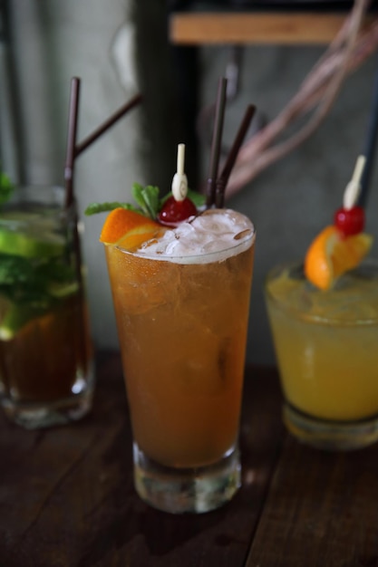 Cóctel Mai Tai con frutos de cereza naranja sobre fondo de madera