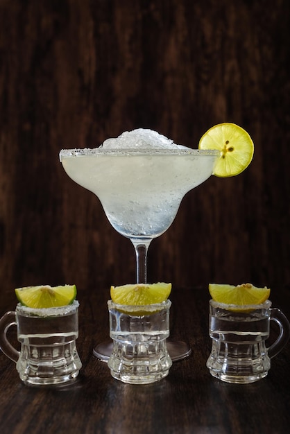 Foto cóctel margarita y tragos de tequila con limón y sal sobre un fondo oscuro bebidas mexicanas