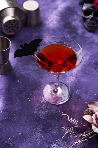 Cóctel de martini de Halloween sobre fondo púrpura