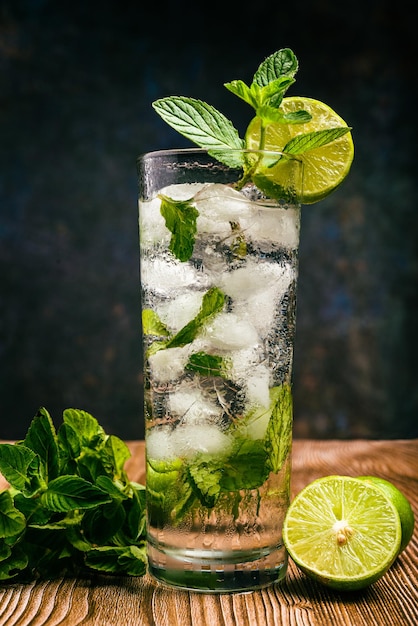 Cóctel mojito decorado con limón y menta sobre una mesa de madera Sin paja