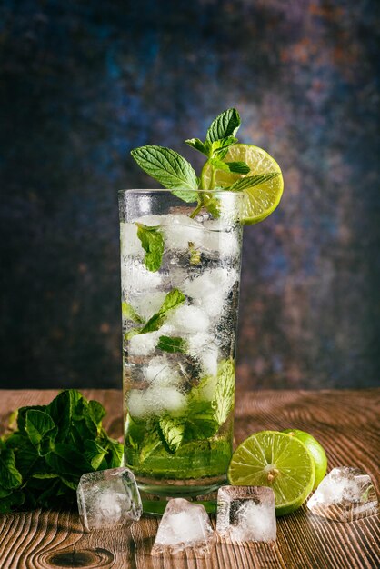 Cóctel mojito decorado con limón y menta sobre una mesa de madera Sin paja