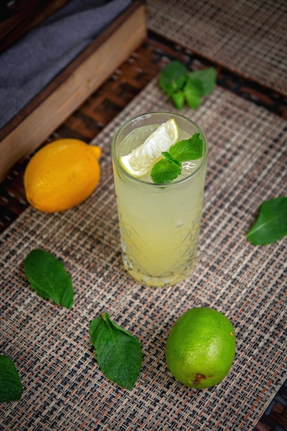 Cóctel de mojito refrescante clásico alcohólico con menta de lima y cubitos de hielo en la terraza de verano del restaurante