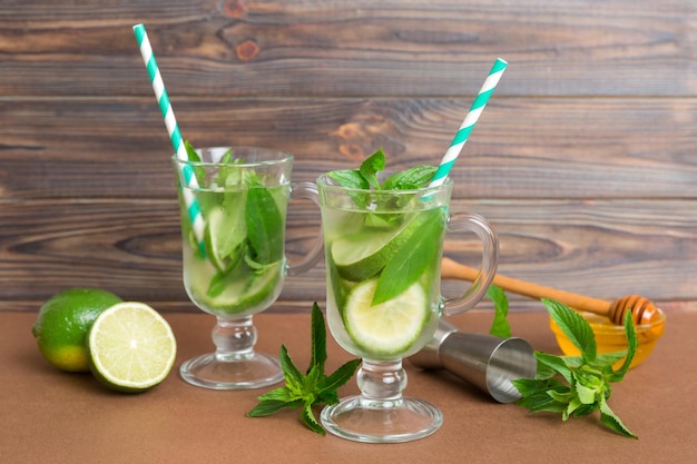 Cóctel de mojito Refrescante cóctel de mojito con lima, limón y menta en un vaso alto con un palo