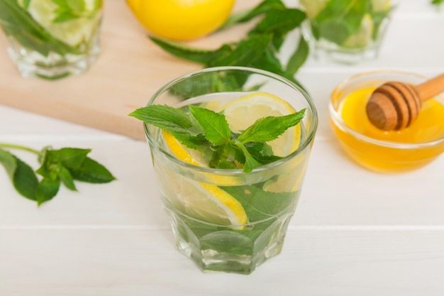 Cóctel de mojito Refrescante cóctel de mojito con lima, limón y menta en un vaso alto con un palo