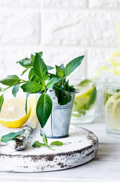 Cóctel Mojito en vaso, limones y hojas de menta