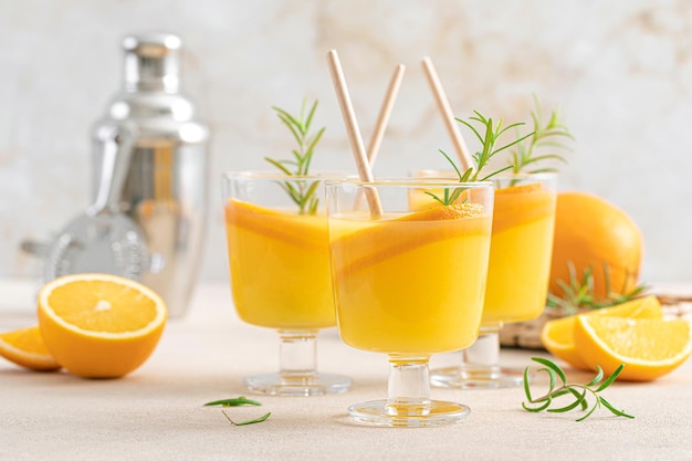 Cóctel de naranja refrescante de verano con romero y frutas frescas