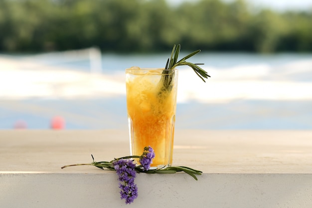 Cóctel de naranja en un vaso. Con decoración floral