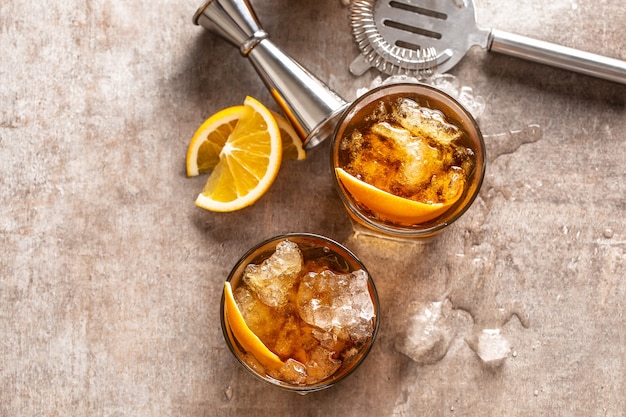 Cóctel Negroni a la antigua con naranja en la barra del bar - vista superior.