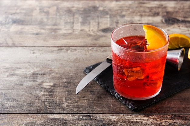 Cóctel Negroni con un trozo de naranja en un vaso