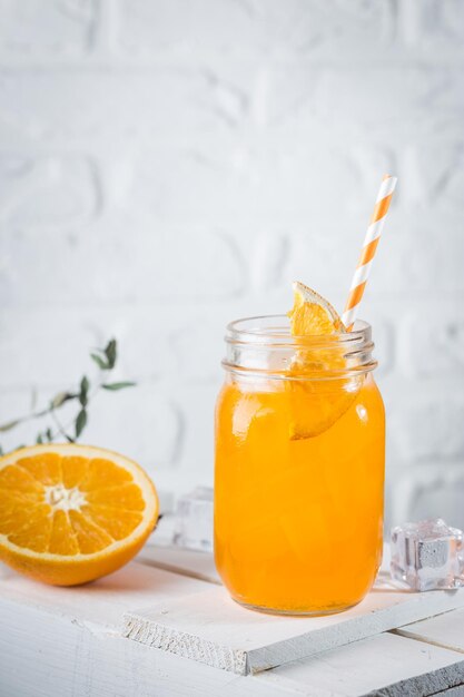 Foto cóctel de orenge de verano fresco en vasos sobre fondo blanco.