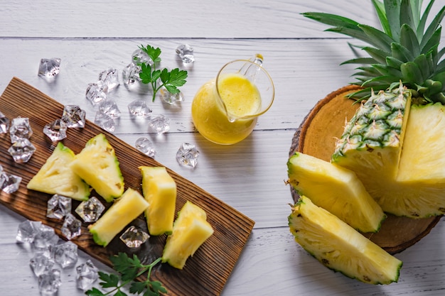 Cóctel de piña o jugo con hielo y piñas sobre un fondo oscuro