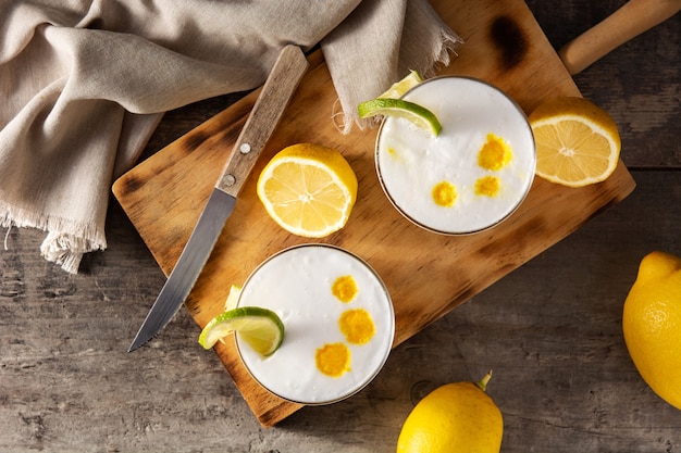 Cóctel de pisco sour en mesa de madera. Cóctel tradicional peruano