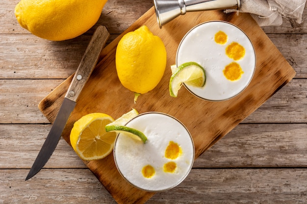 Cóctel de pisco sour en mesa de madera. Cóctel tradicional peruano