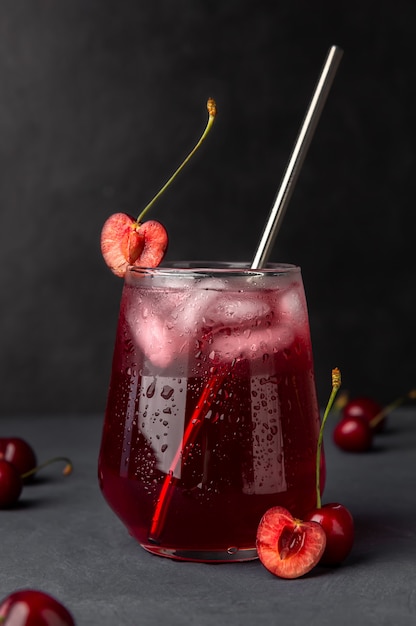 Foto cóctel refrescante con cerezas y hielo.