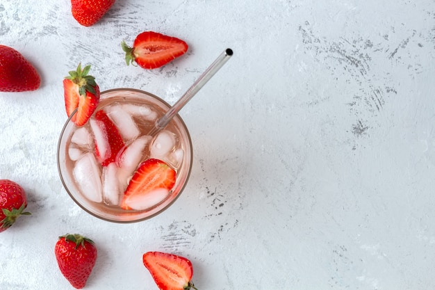 Foto cóctel refrescante con fresas y cubitos de hielo.