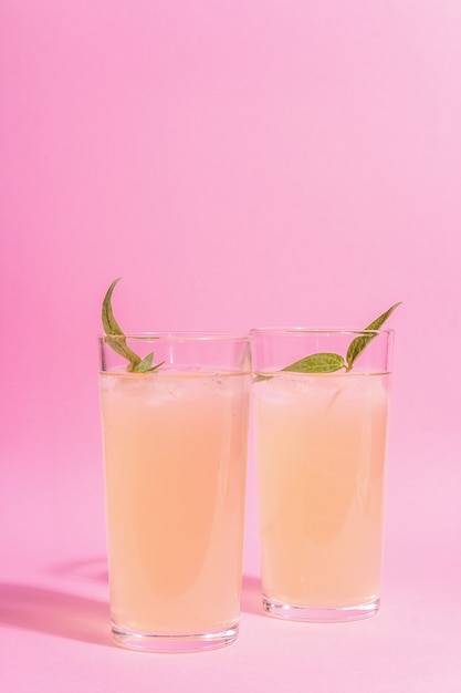 Cóctel refrescante de verano. Bebida dulce fría, luz dura moderna, sombra oscura. Fondo rosa pastel
