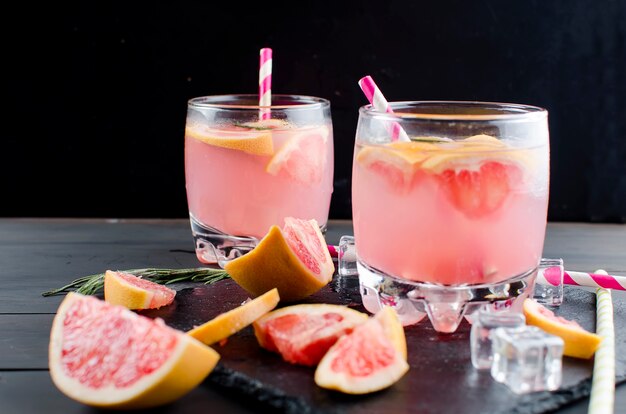 Cóctel con una rodaja de pomelo en una mesa de madera