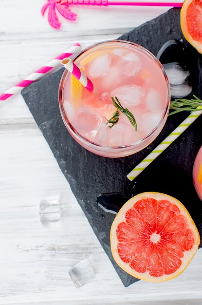 Foto cóctel con una rodaja de pomelo en una mesa de madera