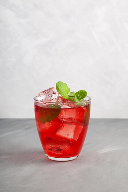 Cóctel rojo de frutas heladas o bebida fría de sandía con hibisco y hoja de menta Bebida refrescante