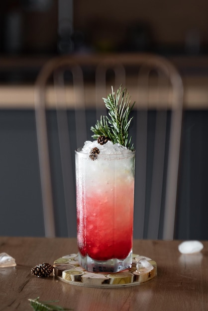 Cóctel rojo hielo con cono de pino y arándano