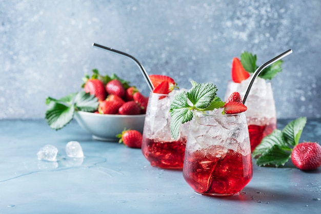 Cóctel rojo con hielo y fresa fresca.