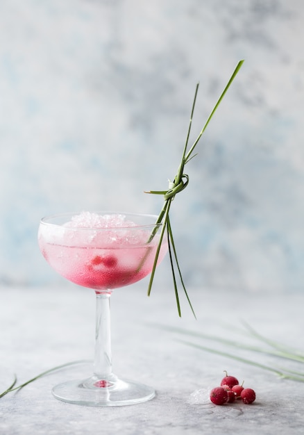 Cóctel rosa de cerca. Bebidas con vino rosado y prosecco en vasos. Exótica porción de cóctel francés con hielo picado en cristalería