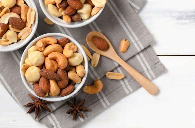 Cóctel salado nueces en madera blanca