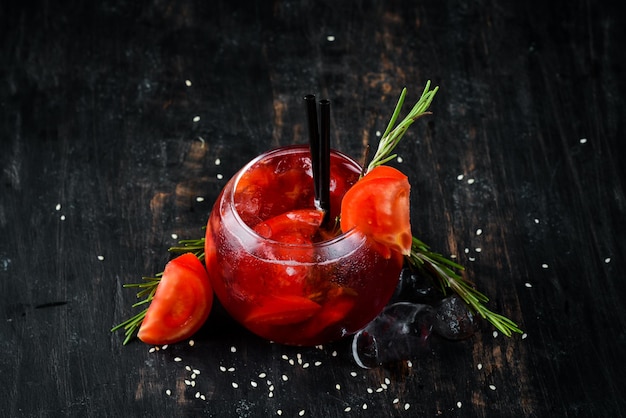 Cóctel de tomate Gin jugo de arándano tomates hielo Sobre un fondo de madera Vista superior