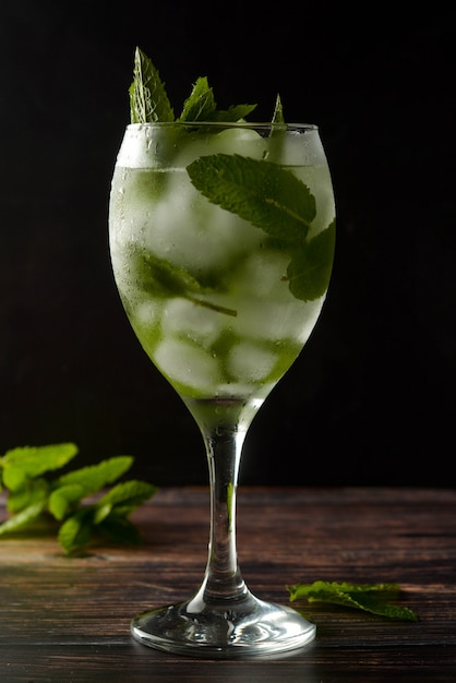 Cóctel de verano o bebida en copa de vino. Bebida refrescante con hojas de menta, gin tonic, jarabe.