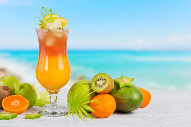 Cóctel de verano con varias frutas tropicales alrededor.